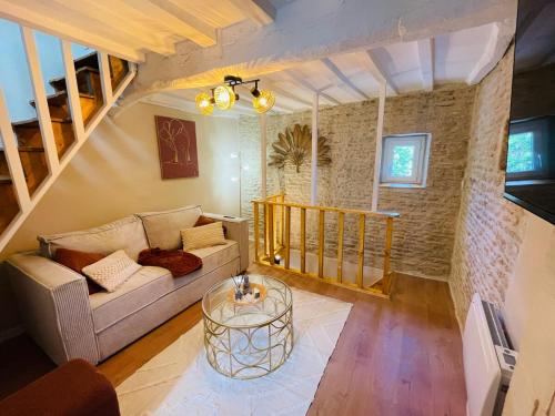 a living room with a couch and a table at Maison de ville avec spa privé in Courseulles-sur-Mer