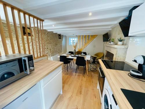 une cuisine avec un comptoir avec un micro-ondes dans l'établissement Maison de ville avec spa privé, à Courseulles-sur-Mer