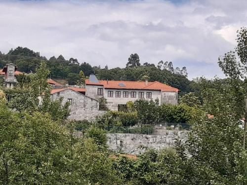 a building on a hill with trees in front of it at Cantinho da Tilde in Fafe