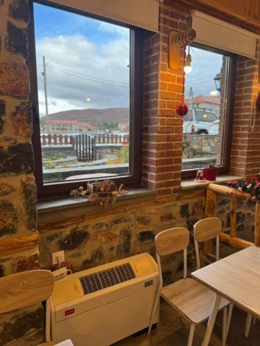 a room with a table and two windows and a heat register at Patriko Mountain Chalet in Palaios Agios Athanasios