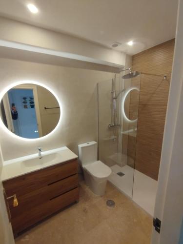 a bathroom with a toilet and a sink and a mirror at Casa Lovia in Orihuela Costa