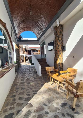 a room with benches and tables in a building at Hotel Leyenda del Tepozteco in Tepoztlán