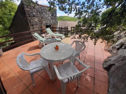 une table et des chaises assises sur une terrasse dans l'établissement Maison de charme, à Vieussan