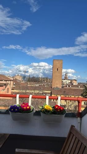 three bowls of flowers sitting on a balcony at Mansarda Le Torri in Mantova