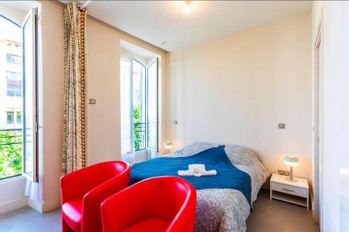 - une chambre avec un lit et deux chaises rouges dans l'établissement Studio hyper-centre de Nice, à Nice