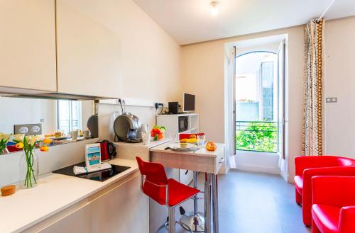une petite cuisine avec une chaise rouge et une table dans l'établissement Studio hyper-centre de Nice, à Nice