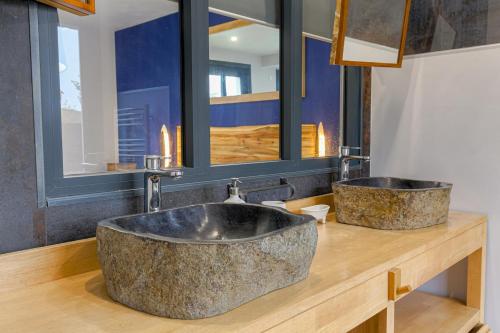 La salle de bains est pourvue d'un grand lavabo en pierre sur un comptoir en bois. dans l'établissement La Fontaine, Maison avec Piscine à 8 mn de Belleville, à Taponas