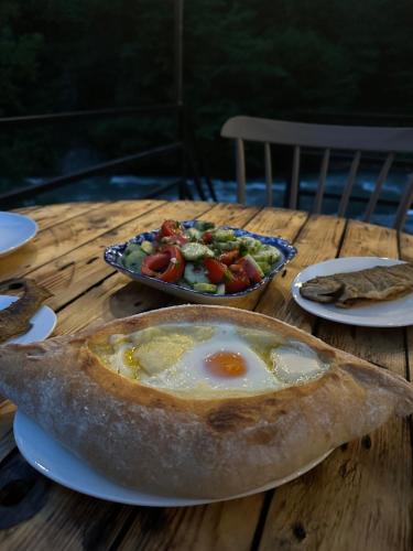 a table with a plate of food with an egg in a pie at A villa in nature in Sindietʼi