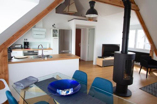 Il comprend une cuisine et un salon avec une cuisinière. dans l'établissement Les Sternes - centre ville- garage, à Concarneau