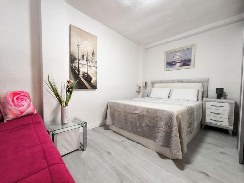 Un dormitorio con una cama y un sofá rojo. en Corazon Benidorm Heart Benidorm, en Benidorm
