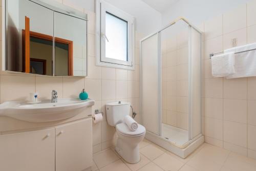 a bathroom with a toilet and a sink and a shower at villa de calme in Pastida