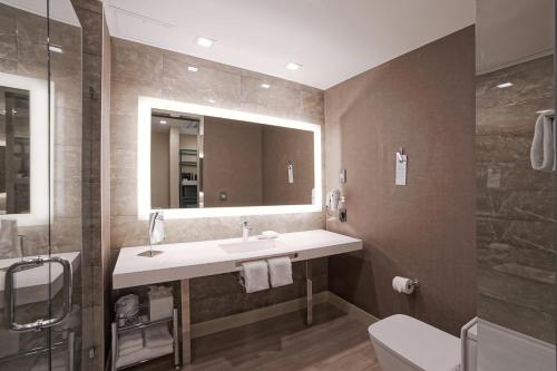 a bathroom with a sink and a mirror at AC Hotel by Marriott Fort Lauderdale Airport in Dania Beach