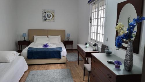 a bedroom with a bed and a table with a vase of flowers at The Blue Hydrangea in Vila Franca do Campo