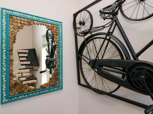 a bike hanging on a wall next to a mirror at Elderflower Lodge in Grange Over Sands