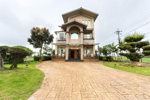 a large house with a large driveway at Mandy's House B&B in Shangwu