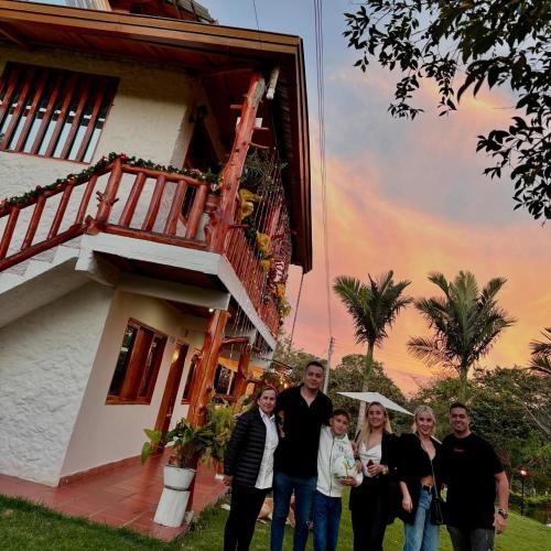 a family poses in front of a house at CABAÑA LOS NOGALES in San Agustín