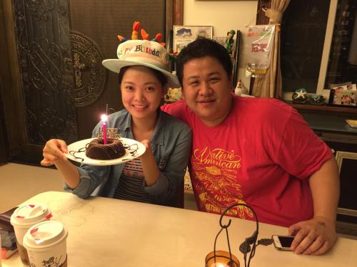 a man and woman sitting at a table with a cake with candles at Mandy's House B&B in Shangwu