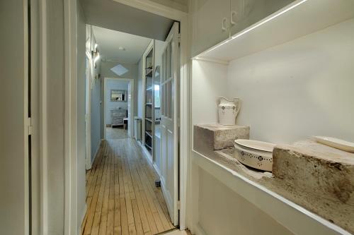 a bathroom with a sink and a hallway at Maison de campagne chez Mamie 4 étoiles in Sainte-Eulalie-dʼAns