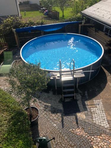 a large blue tub with a ladder in a yard at Ferienwohnung Barbara in Kirchhundem