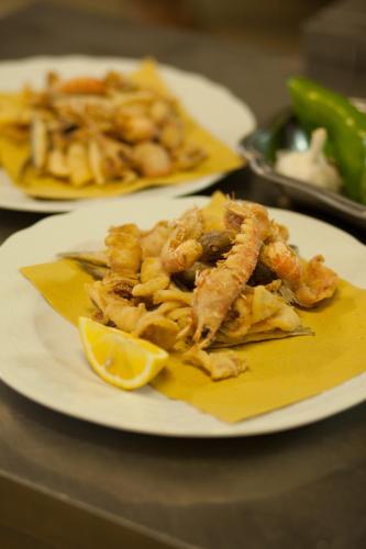 a plate of food with shrimp and a lemon on a table at Hotel Lido in Vasto