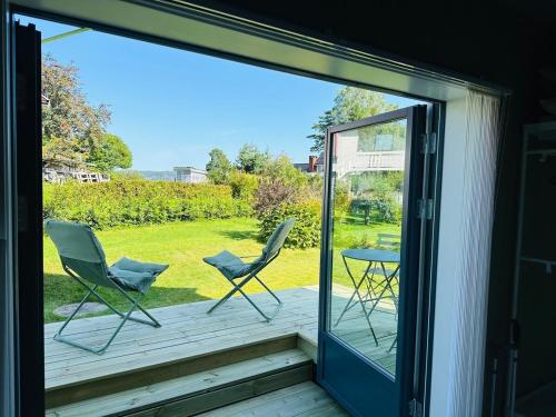 a patio with two chairs and a table on a deck at New apartment in quiet area close to Oslo in Asker