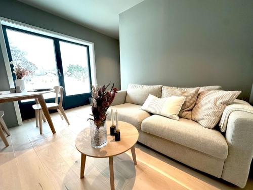 a living room with a couch and a table at New apartment in quiet area close to Oslo in Asker