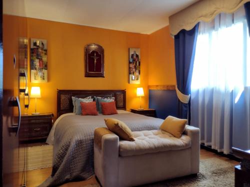a bedroom with a bed and a couch and a window at Casa costa Panitao, Puerto Montt in Puerto Montt