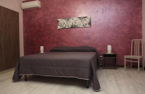 メッシーナにあるB&B Contesseの赤い壁のベッドルーム1室(ベッド1台付)