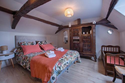 a bedroom with a large bed with red pillows at Maison de campagne chez Mamie 4 étoiles in Sainte-Eulalie-dʼAns