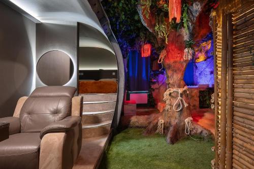 Cette chambre est dotée d'une fresque murale et d'un canapé. dans l'établissement Jungle Crash Love Room, à Unieux