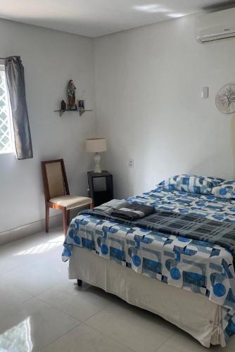 a bedroom with a bed and a chair at Granja Vale das Águas in Igarassu