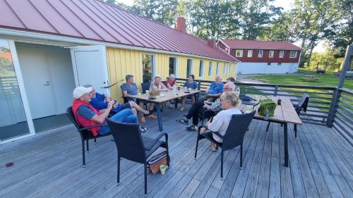 a group of people sitting at tables on a deck at Gula Villan apartment in Västervik