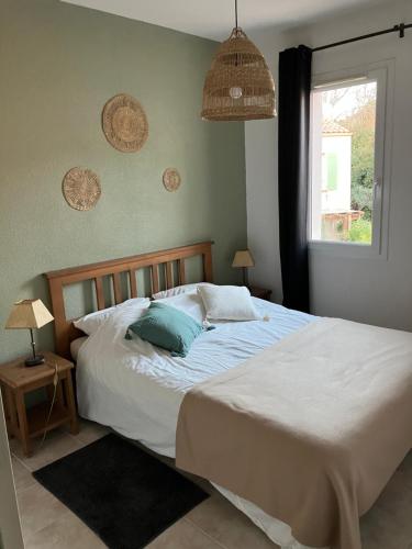 une chambre avec un grand lit avec des oreillers bleus dans l'établissement Maison en Drôme provençale, à Nyons