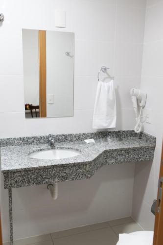 a bathroom with a sink and a mirror at Canasvieiras IN - HCI in Florianópolis