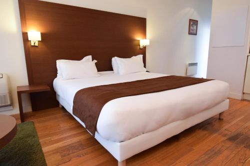 1 cama blanca grande en una habitación de hotel en Residhotel Imperial Rennequin, en París