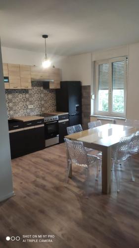 une cuisine avec une table et des chaises dans une pièce dans l'établissement appartement F2 Suite Alyssa, à Auboué