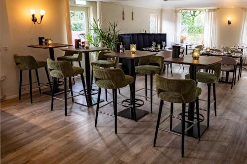 a restaurant with tables and chairs in a room at Strandhotel de Logerij Renesse in Renesse
