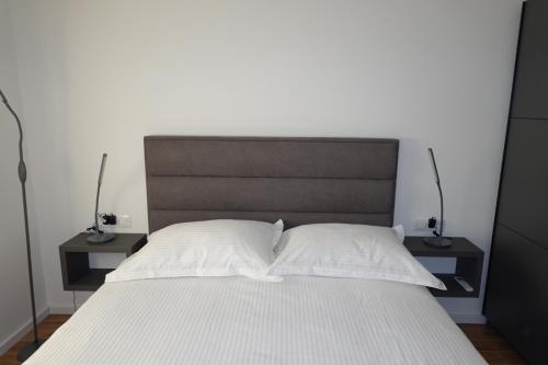 a bed with two nightstands and two white pillows at PERISKA Home in Kaštela