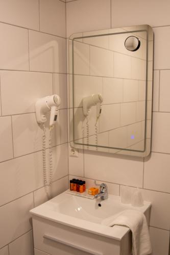 a bathroom with a sink and a mirror at Strandhotel de Logerij Renesse in Renesse