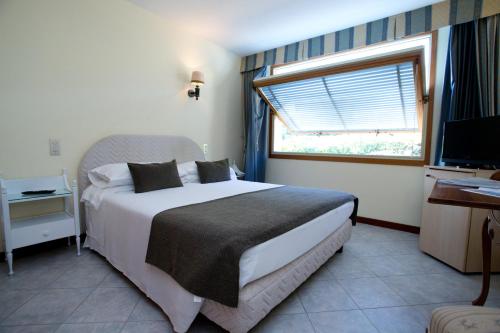 a bedroom with a large bed and a window at Hotel Ristorante Maga Circe in San Felice Circeo
