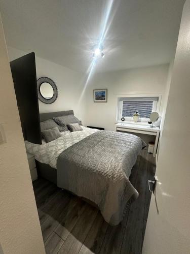 a bedroom with a bed and a desk and a window at Stonehaven Centre - Dunnottar Apartment in Stonehaven