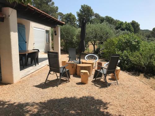 eine Terrasse mit zwei Stühlen und einem Tisch in der Unterkunft Le NORD AU SUD pour 2 personnes in Villecroze