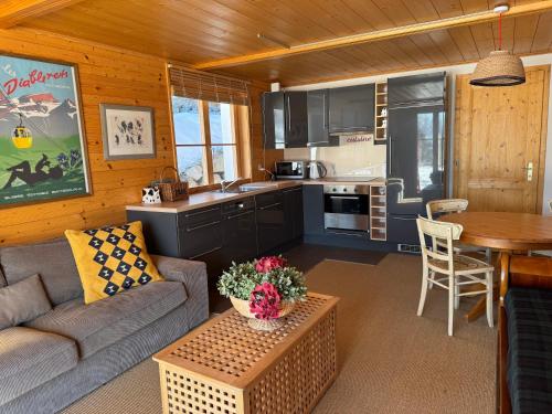 a living room with a couch and a table in a kitchen at Luxury chalet in Les Diablerets Villars ski area in Les Diablerets