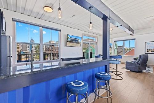 un bar con taburetes azules en una habitación con ventanas en Indy Stadium Villa 711 T, en Indianápolis