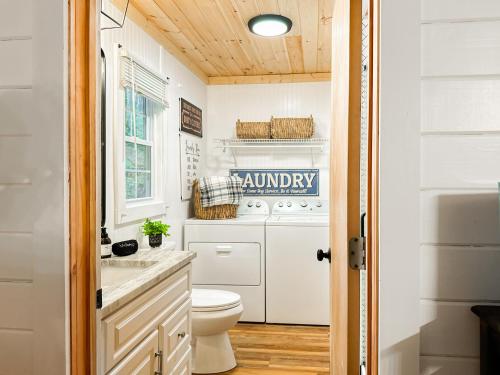 a bathroom with a washer and dryer and a toilet at 200ft Fightingtown Creek Frnthot Tubarcd in Blue Ridge