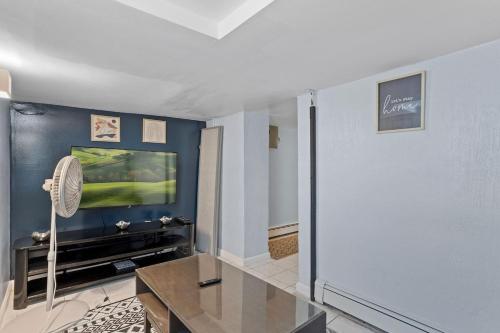 a living room with a table and a tv at Luxury 8 Bedroom House, Steps to Tropicana, Beach and Boardwalk! in Atlantic City