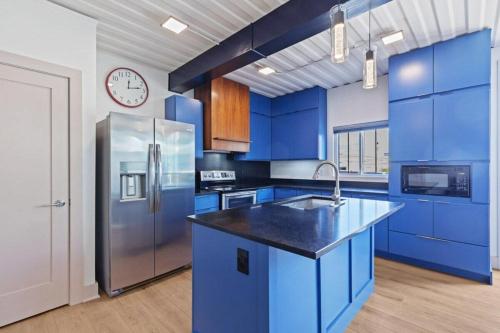 Una cocina con gabinetes azules y un refrigerador de acero inoxidable. en Indy Stadium Villa 711 L, en Indianápolis