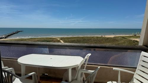 une table et des chaises sur un balcon avec vue sur la plage dans l'établissement Appartement Marina FACE MER, à Saint-Jean-de-Monts