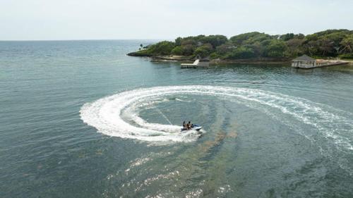 a boat making a wake in the water at Paradise Reef Villas in French Harbour