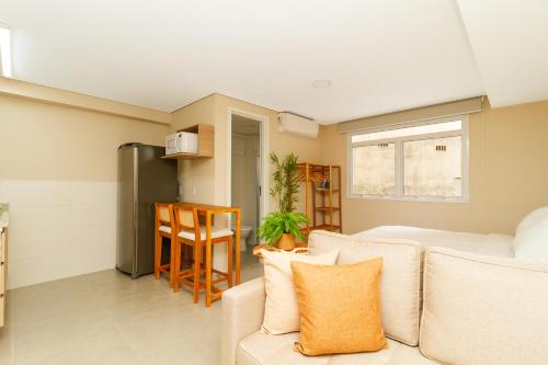 a living room with a couch and a kitchen at 360 Sanfran Riachuelo in Sao Paulo